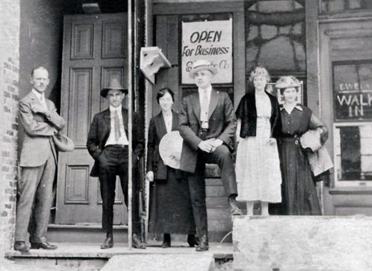 The whole Welke family stands at the stoop of their first shop, circa 1910