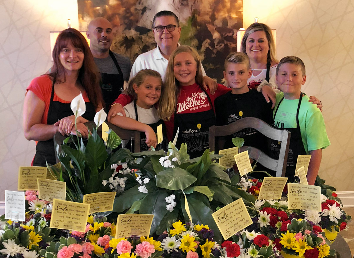 Welke's store operators and floral designers pose with a group of young helpers